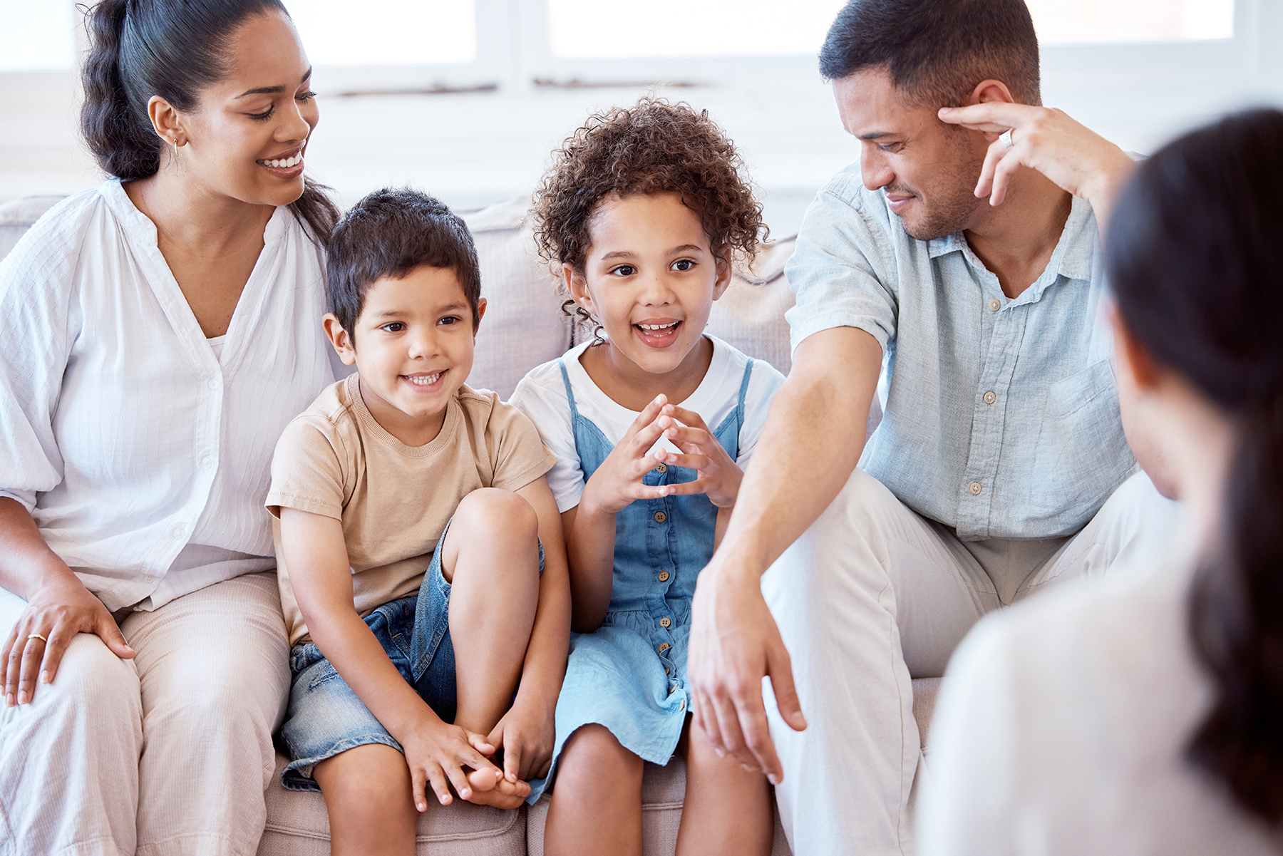 Family sitting on a couch talking to each other