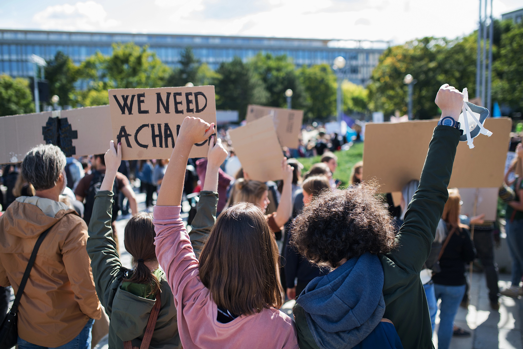 crowd at a protest holding a sign that reads we need a change